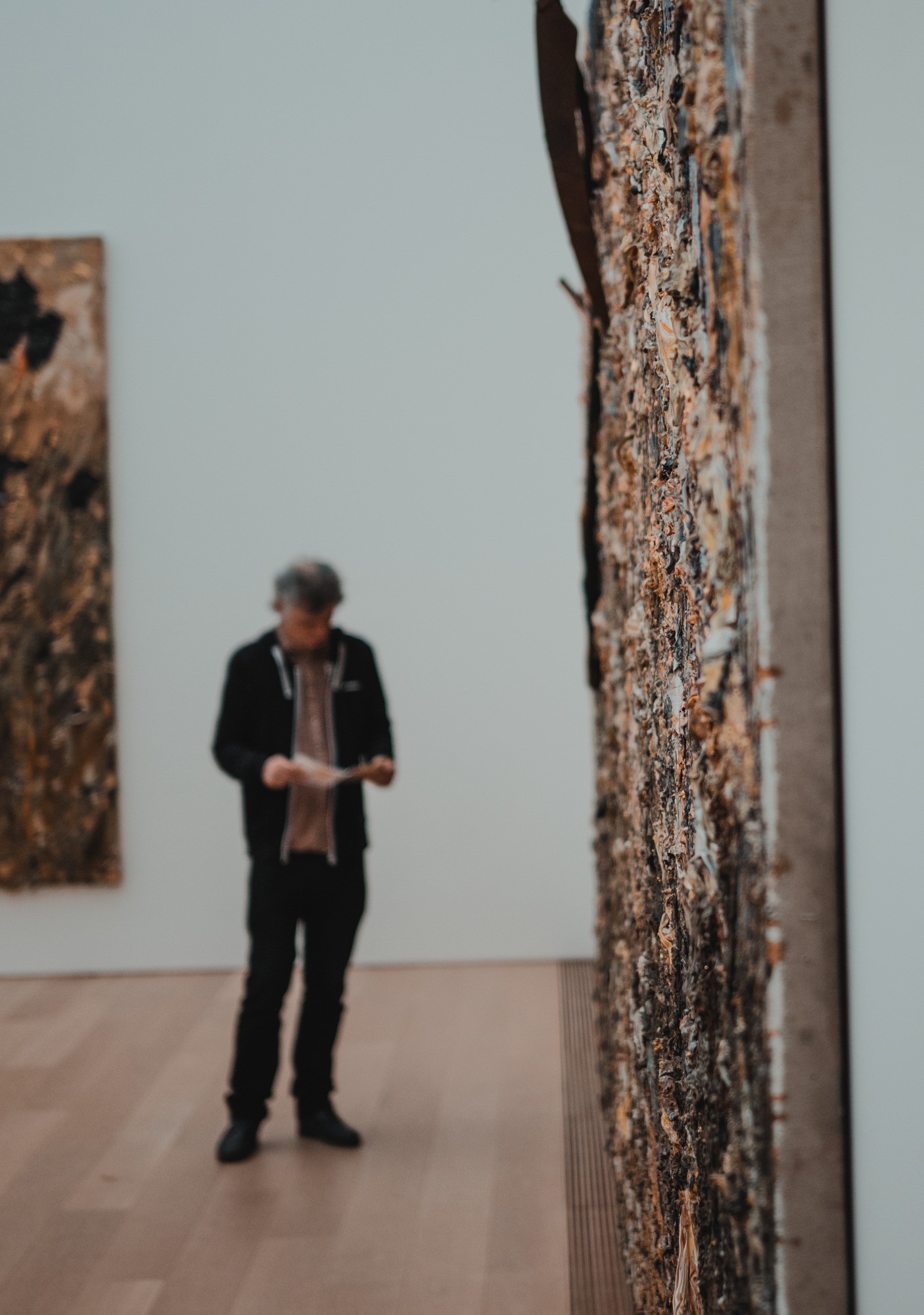 Een man naast een schilderij van Anselm Kiefer in Museum Voorlinden