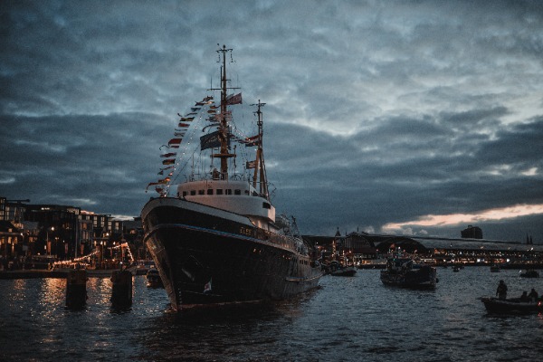 De avond tijdens SAIL Amsterdam, met een grote boot op het water