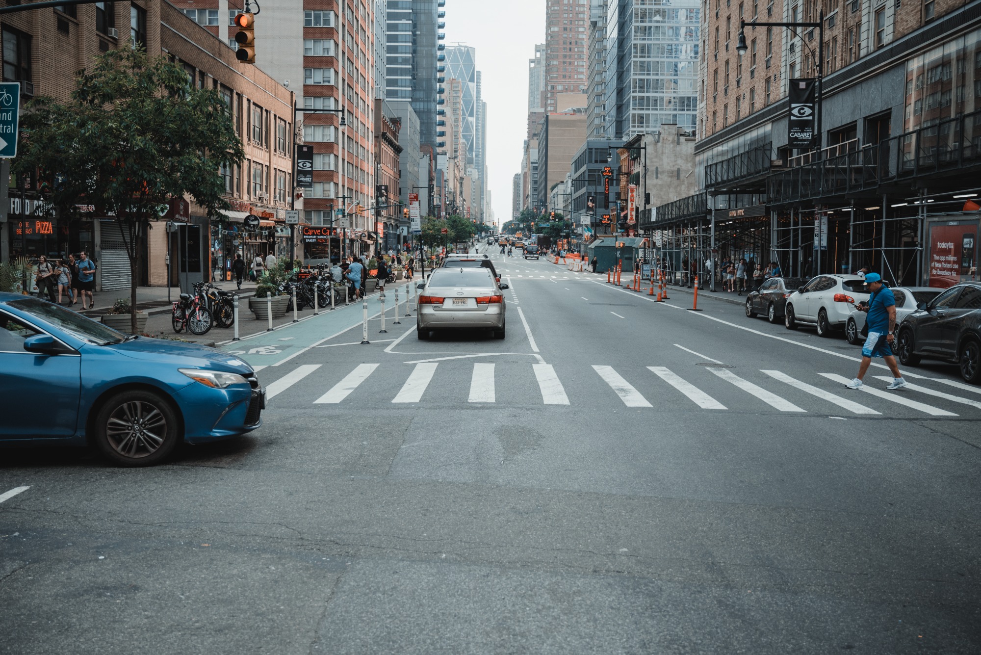 Een drukke straat in New York. We kijken de diepte in langs een aantal auto's.