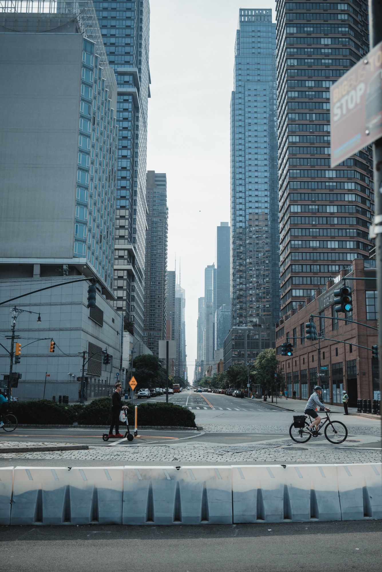 Een drukke straat in New York. We kijken de diepte in langs een aantal fietsers en over een obstakel.