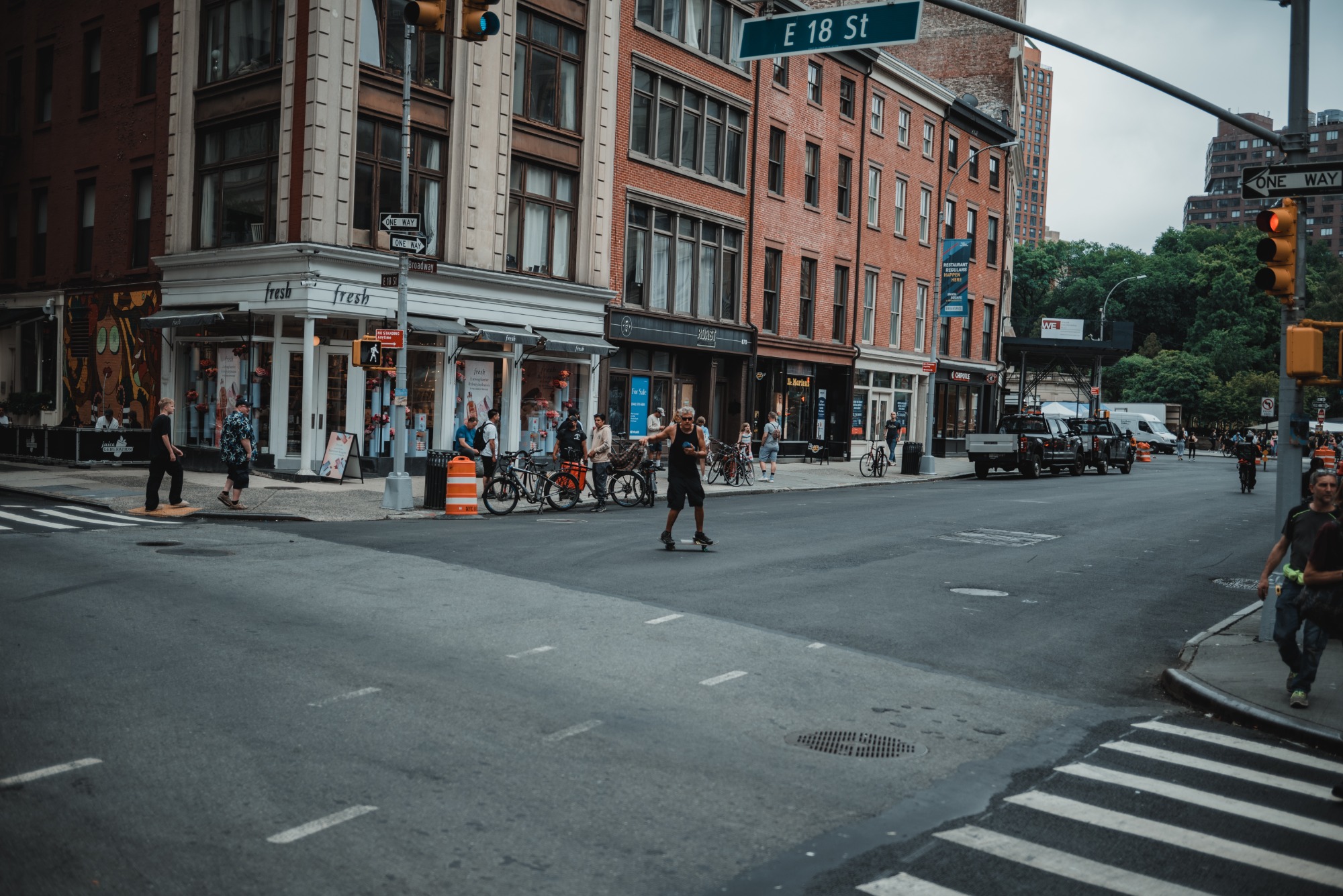 Een kruispunt in New York. Een man op een skateboard staat midden op de weg.