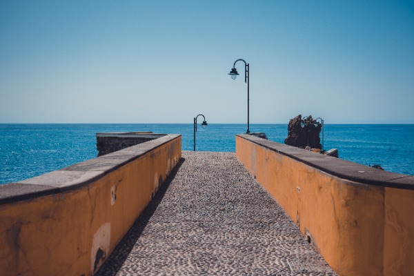 Een klassieke pier met daarachter het blauwe water