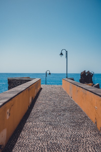 Een klassieke pier met daarachter het blauwe water