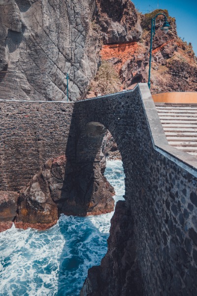 Een brug over wild water aan de kust