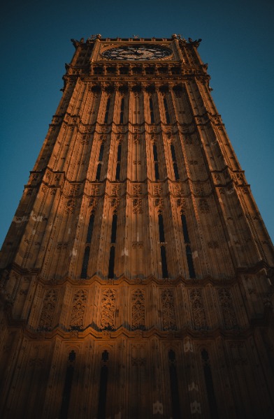 De Big Ben in Londen, van onderaf met het zonlicht erop, op een zomeravond.