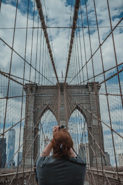 Een vrouw maakt een foto van de Brooklyn Bridge