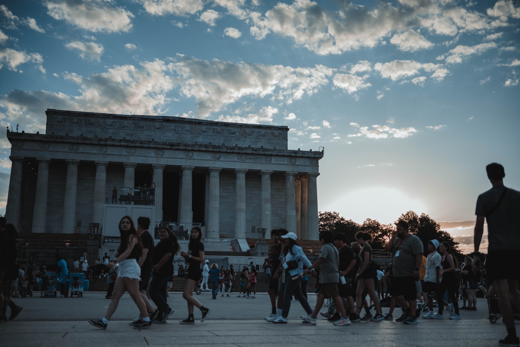 Het Lincoln Memorial tegen een ondergaande zon. Veel mensen lopen voorlangs.