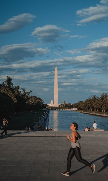 Het Washington Monument. Een hardloper loopt voorbij en we zien de reflection pools.