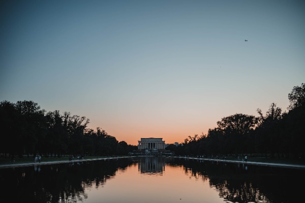 We zien het Lincoln Memorial op afstand, met de reflectie van het monument en de avondlucht in de reflection pools.