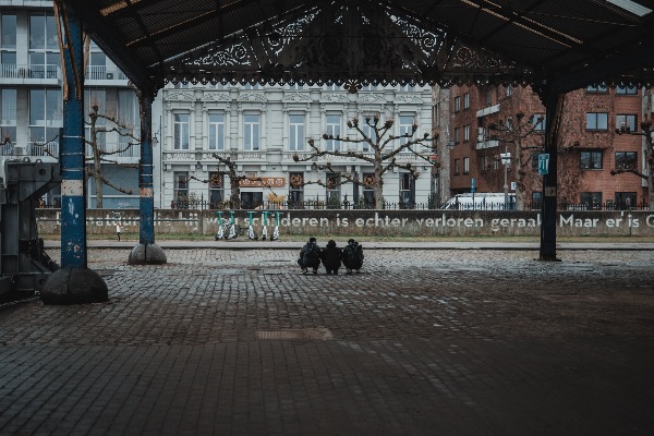 Drie mannen schuilen voor de regen in Antwerpen