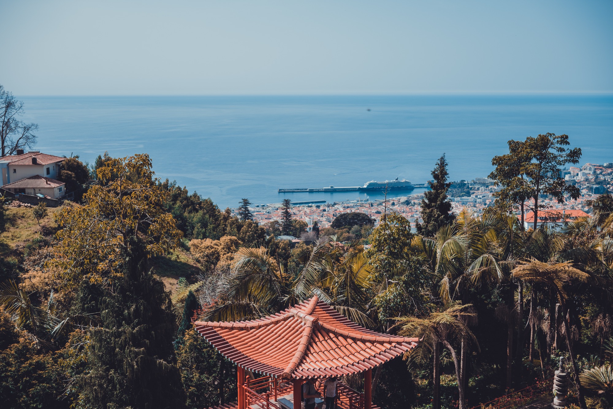 Een gebouw in Aziatische stijl en daarachter het park, nog verder Funchal en daarachter de zee