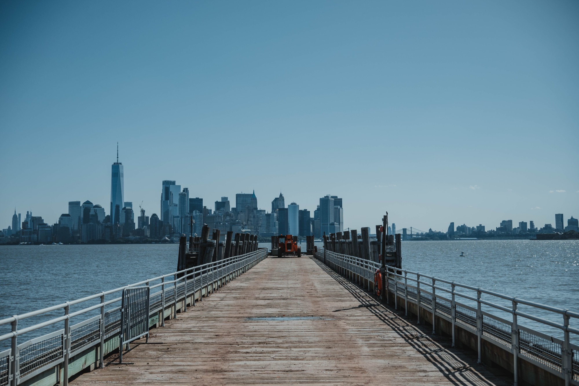 We zien New York achter een lange pier.