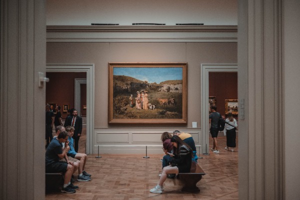 Een schilderij hangt in een hal met bezoekers