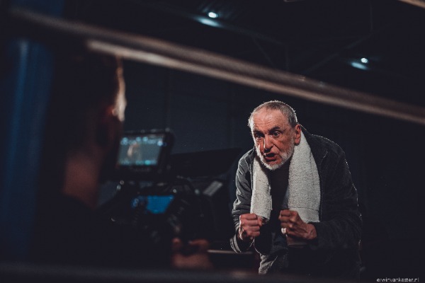 Trainer kijkt naar bokser, cameraman filmt