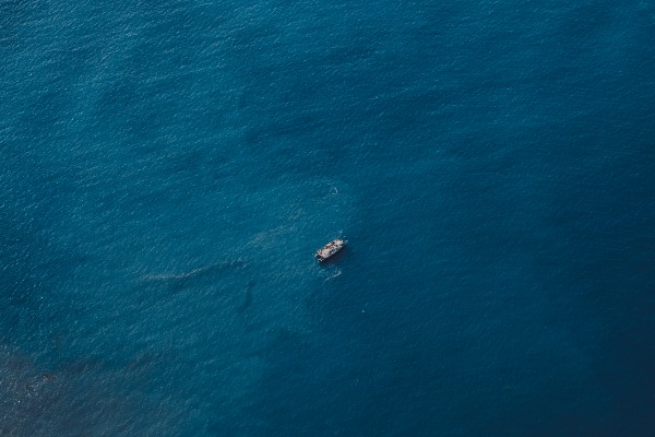 Een enkele boot in het midden van de blauwe zee