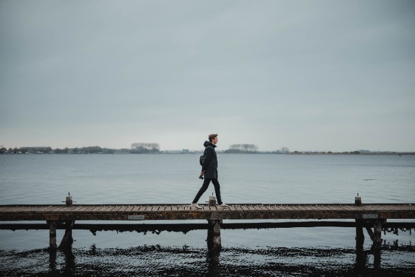 Tim loopt over een vlonder, achter hem het meer bij Veere