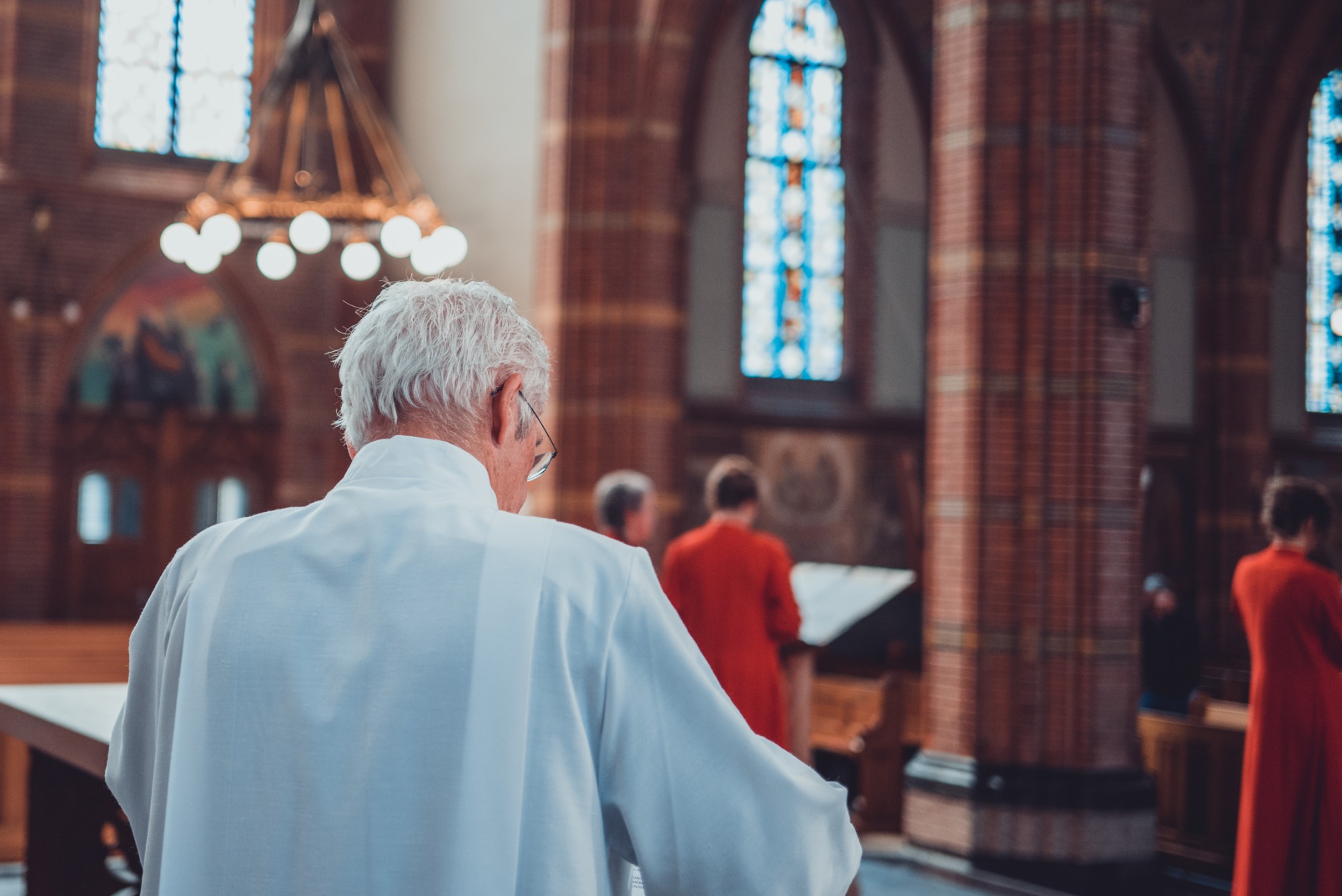 Herman Finkers draagt voor in de kerk. We zien Wishful Singing op de achtergrond.
